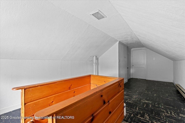 1218 Woodbine Ave, Lansing, MI 48910 - additional living space with vaulted ceiling, a textured ceiling, and baseboards