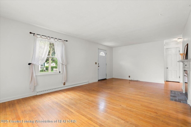 1218 Woodbine Ave, Lansing, MI 48910 - unfurnished living room with a baseboard heating unit, light wood finished floors, a fireplace, and baseboards