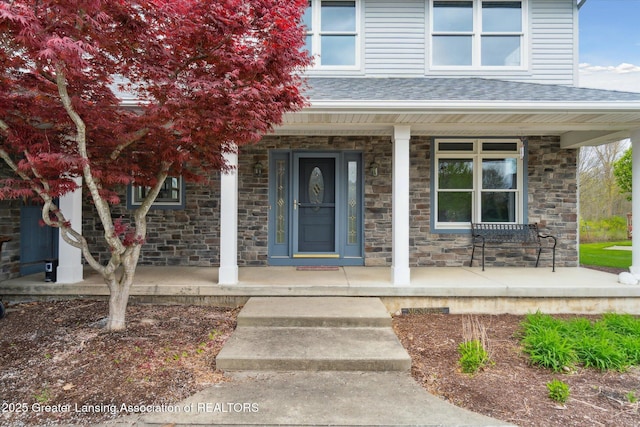549 Riverwalk Dr, Mason, MI 48854 - property entrance with a porch, stone siding, and a shingled roof