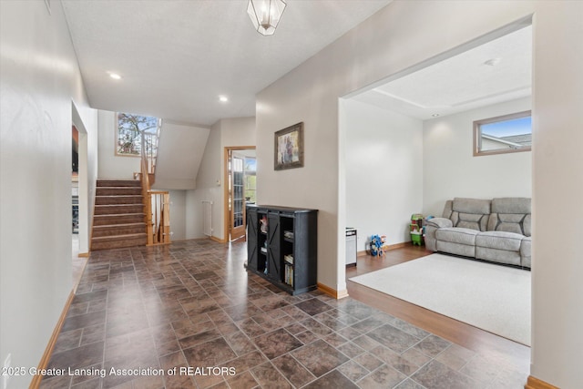 549 Riverwalk Dr, Mason, MI 48854 - living area with dark stone finish floors, stairs, baseboards, and recessed lighting