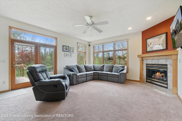 549 Riverwalk Dr, Mason, MI 48854 - carpeted living room with healthy amount of natural light, a tiled fireplace, a ceiling fan, recessed lighting, and a textured ceiling