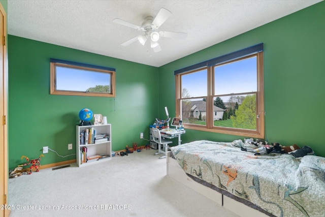 549 Riverwalk Dr, Mason, MI 48854 - bedroom featuring multiple windows, carpet floors, a textured ceiling, baseboards, and ceiling fan