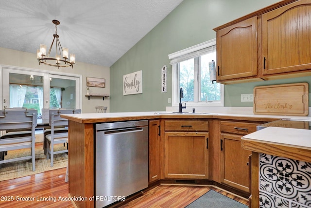 722 Fieldview Dr, Grand Ledge, MI 48837 - kitchen with dishwasher, a sink, vaulted ceiling, light wood-type flooring, and a chandelier