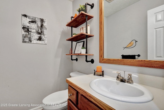 722 Fieldview Dr, Grand Ledge, MI 48837 - half bath with vanity, toilet, and a textured ceiling