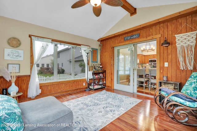 722 Fieldview Dr, Grand Ledge, MI 48837 - living room with wood walls, wood finished floors, a chandelier, and ceiling fan