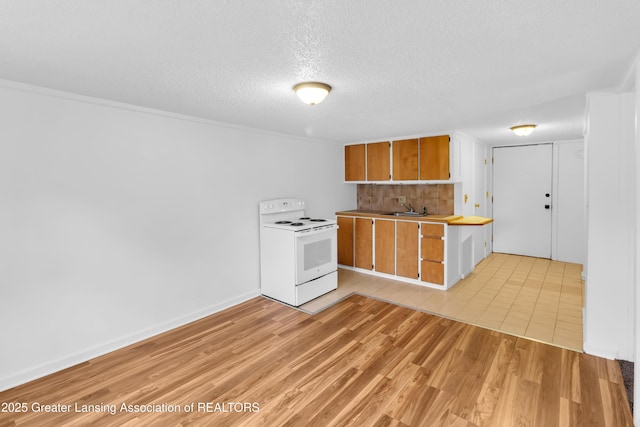 316 S Rosemary Ave, Lansing, MI 48917 - kitchen with electric stove, backsplash, light wood-type flooring, a textured ceiling, and brown cabinets