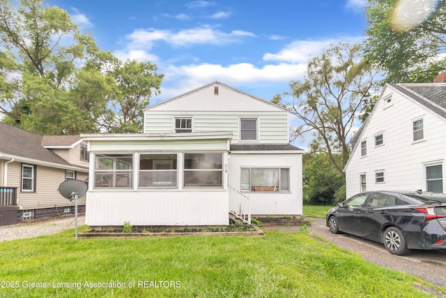 316 S Rosemary Ave, Lansing, MI 48917 - view of front of home featuring a sunroom, roof with shingles, and a front yard
