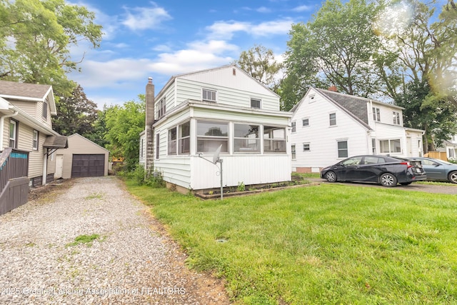 316 S Rosemary Ave, Lansing, MI 48917 - view of front of home featuring an outdoor structure, a sunroom, a garage, a front yard, and a chimney