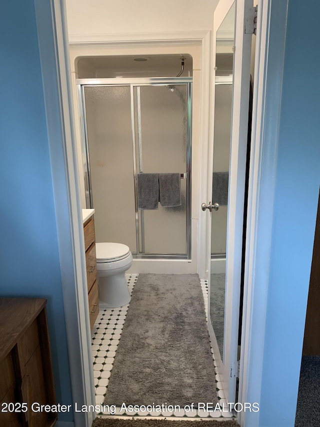 575 Brookland Blvd, Lansing, MI 48910 - bathroom with toilet, a shower stall, vanity, and tile patterned floors