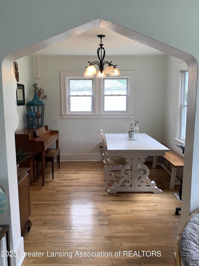 575 Brookland Blvd, Lansing, MI 48910 - dining area featuring light wood finished floors, a chandelier, and baseboards