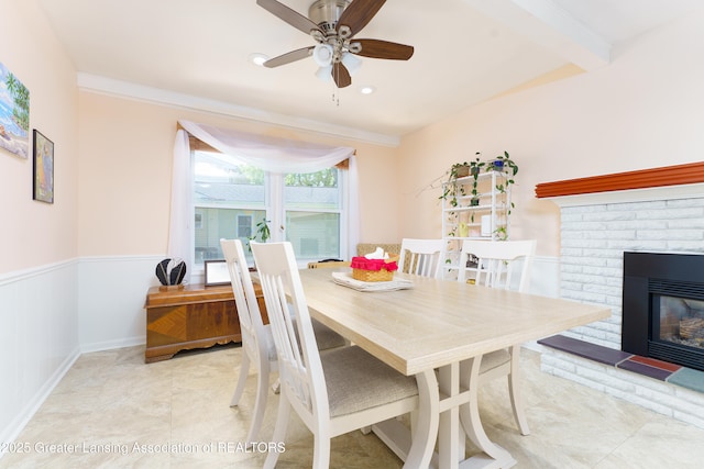 2305 Post Oak Ln, Lansing, MI 48912 - dining area featuring a ceiling fan, a wainscoted wall, a fireplace, and ornamental molding