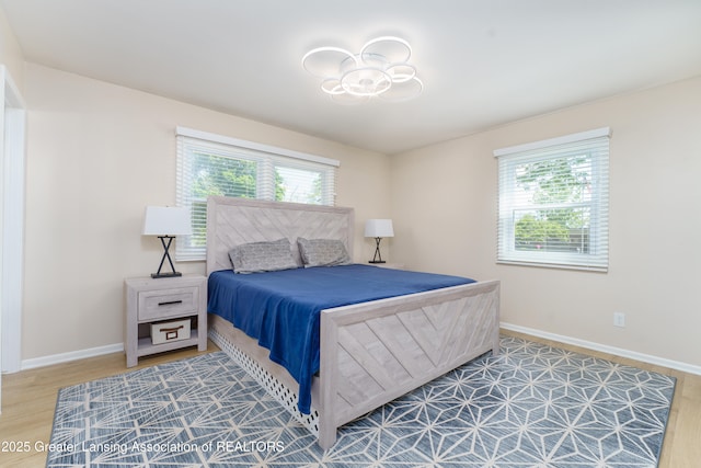 2305 Post Oak Ln, Lansing, MI 48912 - bedroom featuring multiple windows, wood finished floors, and baseboards