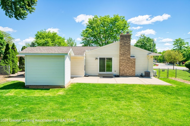 2305 Post Oak Ln, Lansing, MI 48912 - back of property with a patio, a chimney, central air condition unit, a shingled roof, and an outbuilding