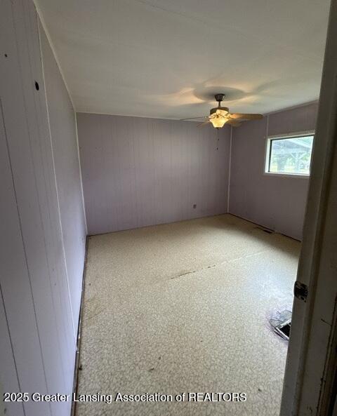 9882 W M 21, Ovid, MI 48866 - unfurnished room with a ceiling fan and wooden walls