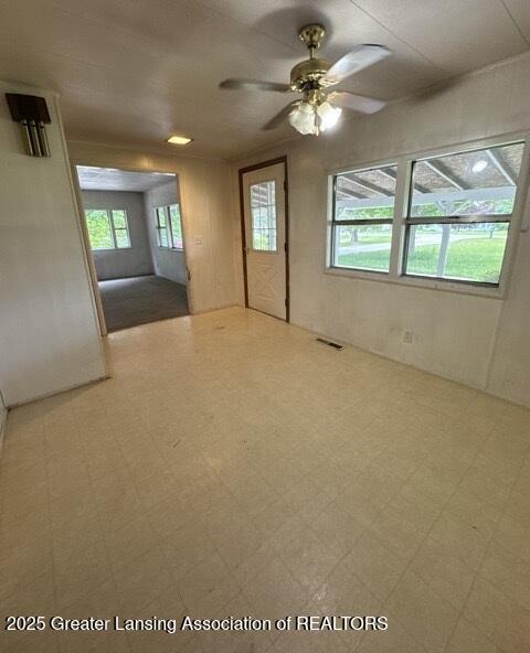 9882 W M 21, Ovid, MI 48866 - empty room featuring healthy amount of natural light, tile patterned floors, and ceiling fan