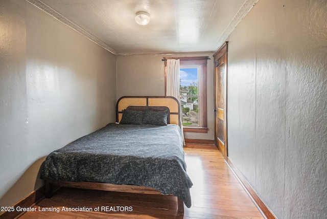 1417 W Ottawa St, Lansing, MI 48915 - bedroom with light wood-type flooring, ornamental molding, and baseboards