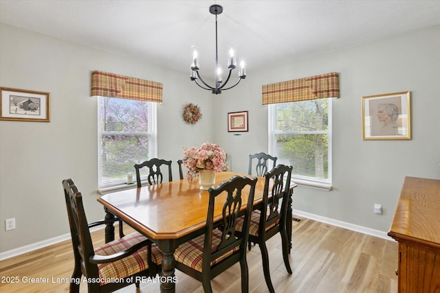 1990 S Waverly Rd, Eaton Rapids, MI 48827 - dining room featuring a chandelier, light wood-style floors, and baseboards