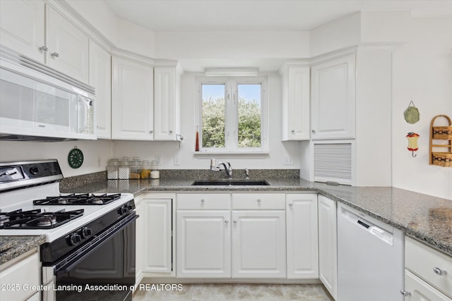 1990 S Waverly Rd, Eaton Rapids, MI 48827 - kitchen with range with gas cooktop, white microwave, dishwasher, a sink, and white cabinetry