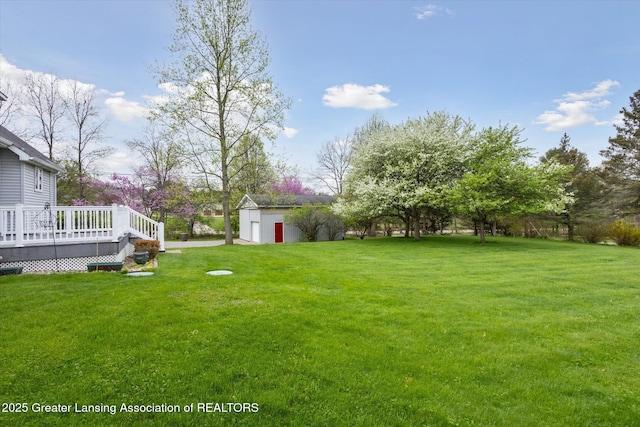 1990 S Waverly Rd, Eaton Rapids, MI 48827 - view of green lawn featuring a deck and an outbuilding