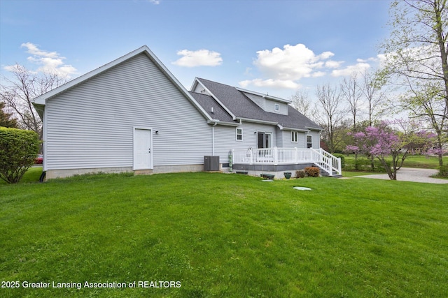 1990 S Waverly Rd, Eaton Rapids, MI 48827 - rear view of house featuring a deck, a shingled roof, and a yard