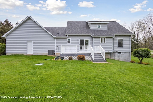 1990 S Waverly Rd, Eaton Rapids, MI 48827 - rear view of property featuring central AC unit, a shingled roof, a deck, and a lawn