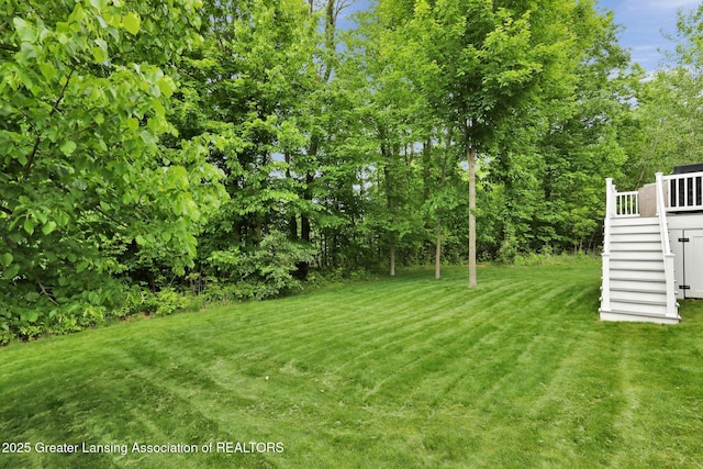 4269 Tamarack St, Holt, MI 48842 - view of green lawn with stairs and a deck