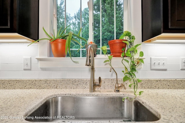 4269 Tamarack St, Holt, MI 48842 - kitchen view of a sink, backsplash, and light stone countertops