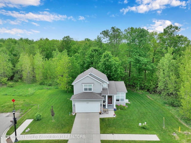4269 Tamarack St, Holt, MI 48842 - view of front of property featuring concrete driveway, a front lawn, an attached garage, and a view of trees
