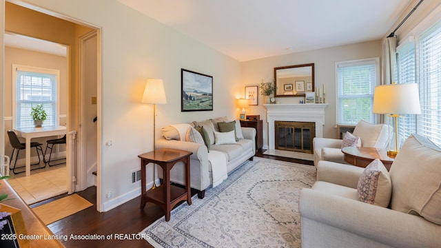 1451 Harvard Rd, East Lansing, MI 48823 - living room featuring wood finished floors, plenty of natural light, baseboards, and a fireplace with flush hearth