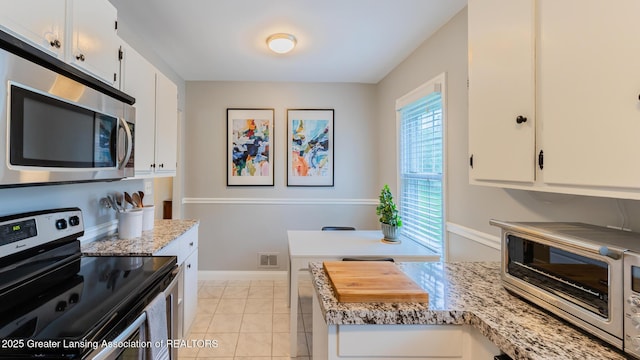 1451 Harvard Rd, East Lansing, MI 48823 - kitchen featuring appliances with stainless steel finishes, white cabinets, baseboards, and light stone countertops