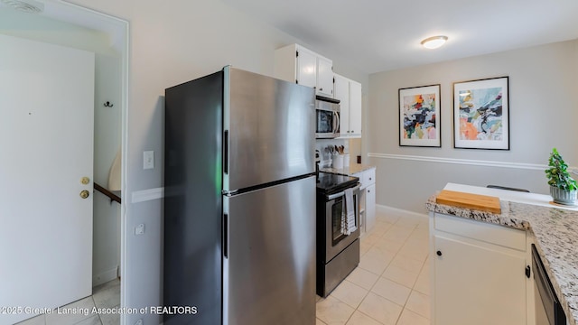1451 Harvard Rd, East Lansing, MI 48823 - kitchen featuring appliances with stainless steel finishes, white cabinets, light tile patterned floors, and light stone countertops