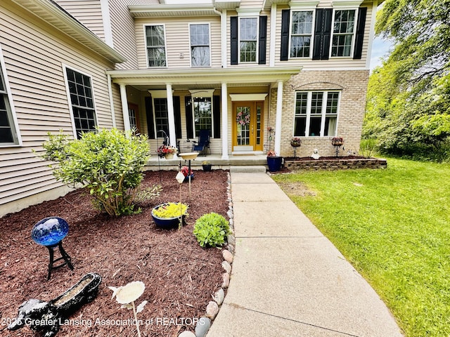 11195 W Herbison Rd, Eagle, MI 48822 - property entrance featuring a lawn, a porch, and brick siding