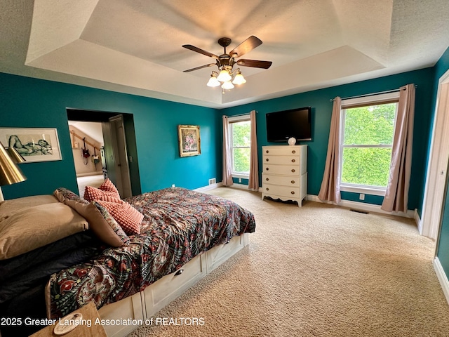 11195 W Herbison Rd, Eagle, MI 48822 - bedroom featuring a tray ceiling, carpet flooring, baseboards, a textured ceiling, and a ceiling fan