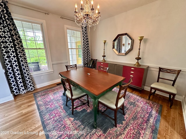 11195 W Herbison Rd, Eagle, MI 48822 - dining area with a chandelier, wood finished floors, and baseboards