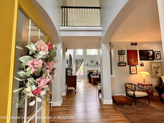 11195 W Herbison Rd, Eagle, MI 48822 - foyer entrance featuring arched walkways, wood finished floors, baseboards, and a towering ceiling