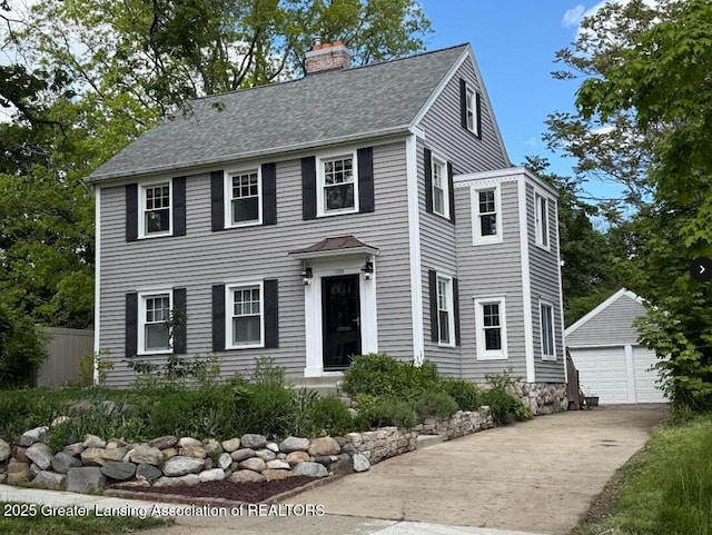 350 Kensington Rd, East Lansing, MI 48823 - colonial house with an outdoor structure, a chimney, a detached garage, and roof with shingles