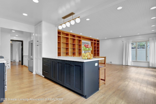 350 Kensington Rd, East Lansing, MI 48823 - kitchen featuring light wood-style flooring, light countertops, a kitchen breakfast bar, recessed lighting, and a peninsula