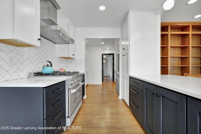 350 Kensington Rd, East Lansing, MI 48823 - kitchen with wall chimney range hood, stainless steel range, white cabinets, backsplash, and light countertops