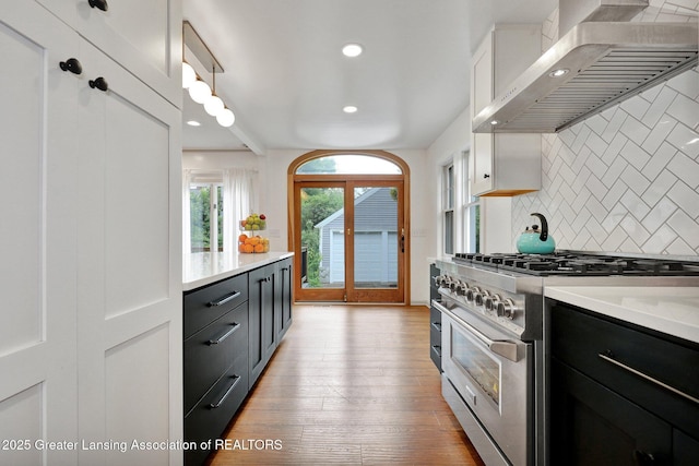 350 Kensington Rd, East Lansing, MI 48823 - kitchen with high end stainless steel range oven, wall chimney exhaust hood, decorative backsplash, light countertops, and recessed lighting
