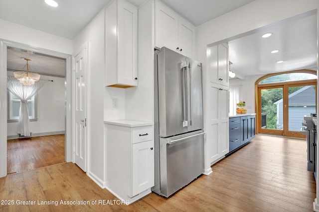 350 Kensington Rd, East Lansing, MI 48823 - kitchen with high quality fridge, white cabinets, a chandelier, light countertops, and light wood finished floors