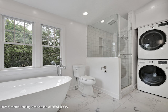 350 Kensington Rd, East Lansing, MI 48823 - full bathroom with stacked washer / dryer, marble finish flooring, a stall shower, a freestanding bath, and recessed lighting