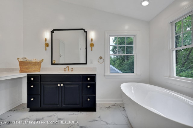 350 Kensington Rd, East Lansing, MI 48823 - bathroom with plenty of natural light, a soaking tub, marble look tile flooring, vanity, and vaulted ceiling