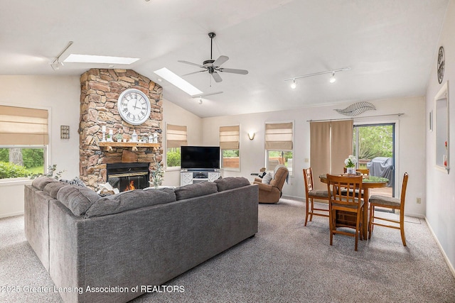 8450 Pineview Lake Dr, Linden, MI 48451 - living room with ceiling fan, light colored carpet, healthy amount of natural light, vaulted ceiling, and a fireplace