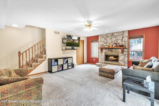 524 Dutch Hill Dr, Lansing, MI 48917 - living area with carpet flooring, a ceiling fan, baseboards, stairs, and a fireplace