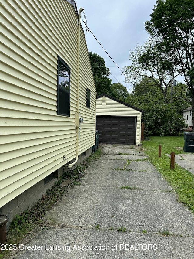 657 Spartan Ave, East Lansing, MI 48823 - view of side of property with a detached garage and an outbuilding