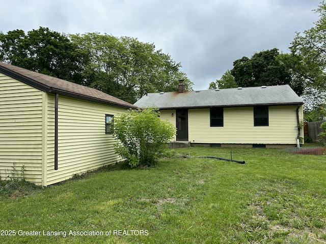 657 Spartan Ave, East Lansing, MI 48823 - rear view of property featuring a lawn and a chimney