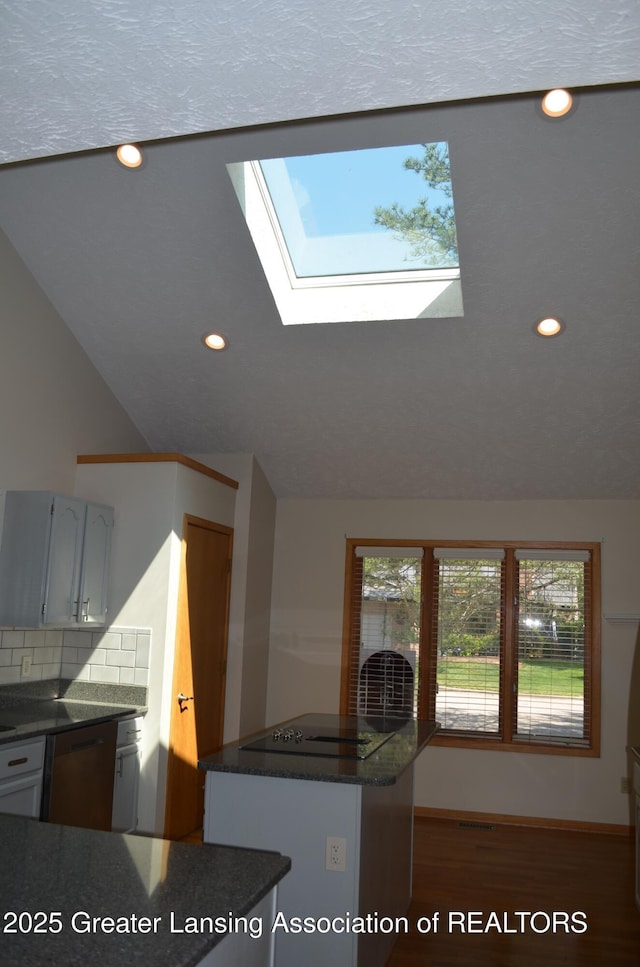 2397 Emerald Forest Cir Unit 26, East Lansing, MI 48823 - kitchen featuring black electric cooktop, a skylight, recessed lighting, decorative backsplash, and a center island