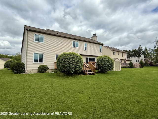 1512 Lindy Dr, Lansing, MI 48917 - back of property with a chimney, a lawn, and a deck