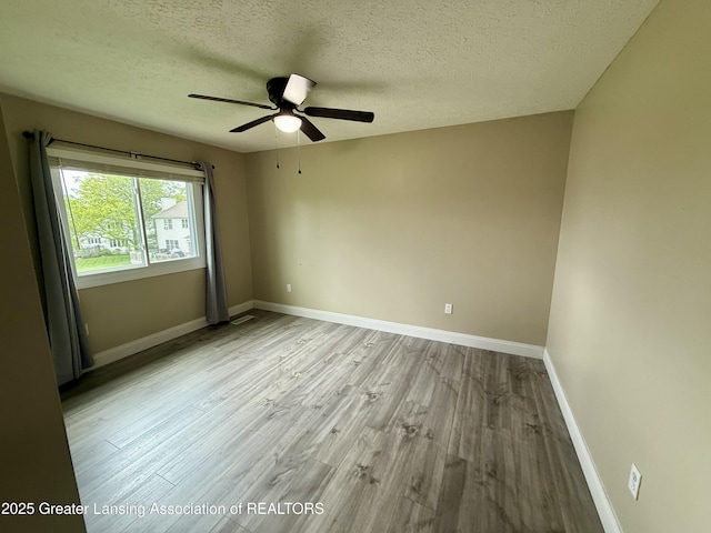1512 Lindy Dr, Lansing, MI 48917 - spare room with ceiling fan, wood finished floors, baseboards, and a textured ceiling