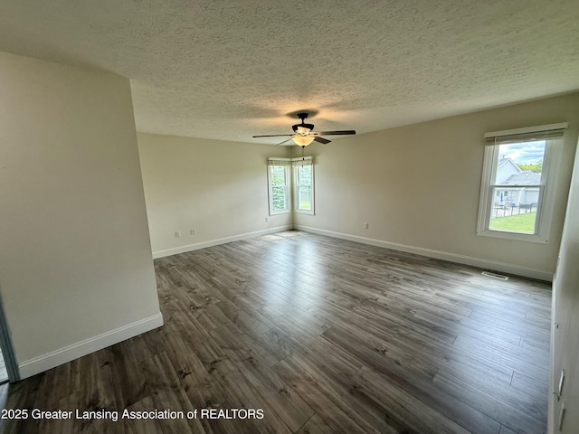 1512 Lindy Dr, Lansing, MI 48917 - spare room with a textured ceiling, ceiling fan, dark wood-style floors, and baseboards